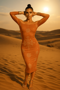 Elegant baroque off shoulder midi dress in warm orange with floral patterns worn by model in desert sunset