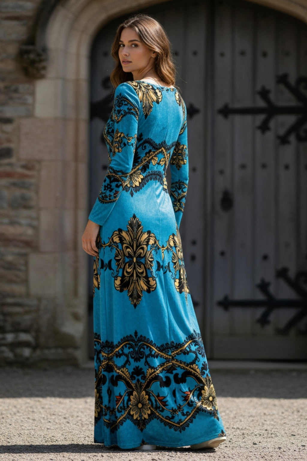 Woman wearing baroque print velvet maxi dress in blue and gold by Angelic Blessings Shop standing outdoors