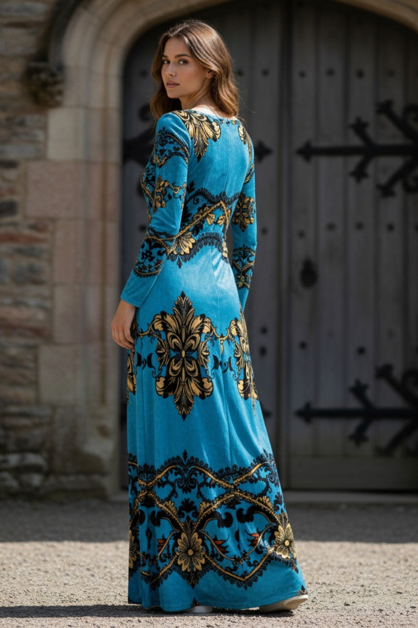 Woman wearing baroque print velvet maxi dress in blue and gold by Angelic Blessings Shop standing outdoors