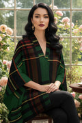 Woman wearing Cramond tartan ruana shawl with green and black plaid sitting in floral garden