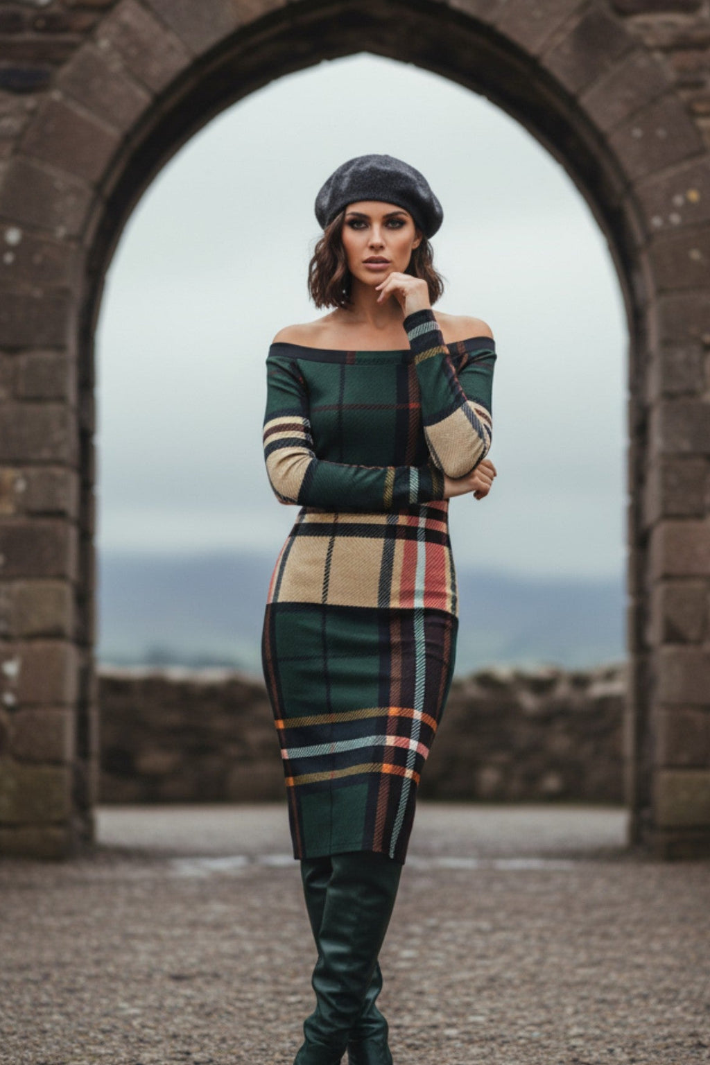 Woman wearing tartan off the shoulder midi dress with green and beige plaid pattern and black beret